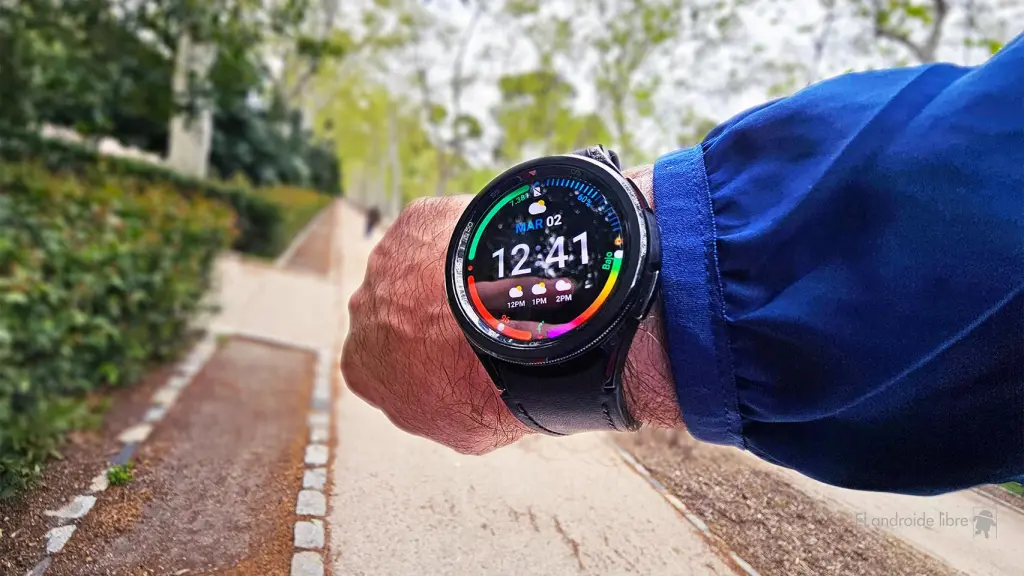 Anillo Inteligente vs. Smartwatch 2 tleta usando un smartwatch para monitorear su salud durante una carrera, demostrando la ventaja del smartwatch sobre un anillo inteligente en tiempo real.